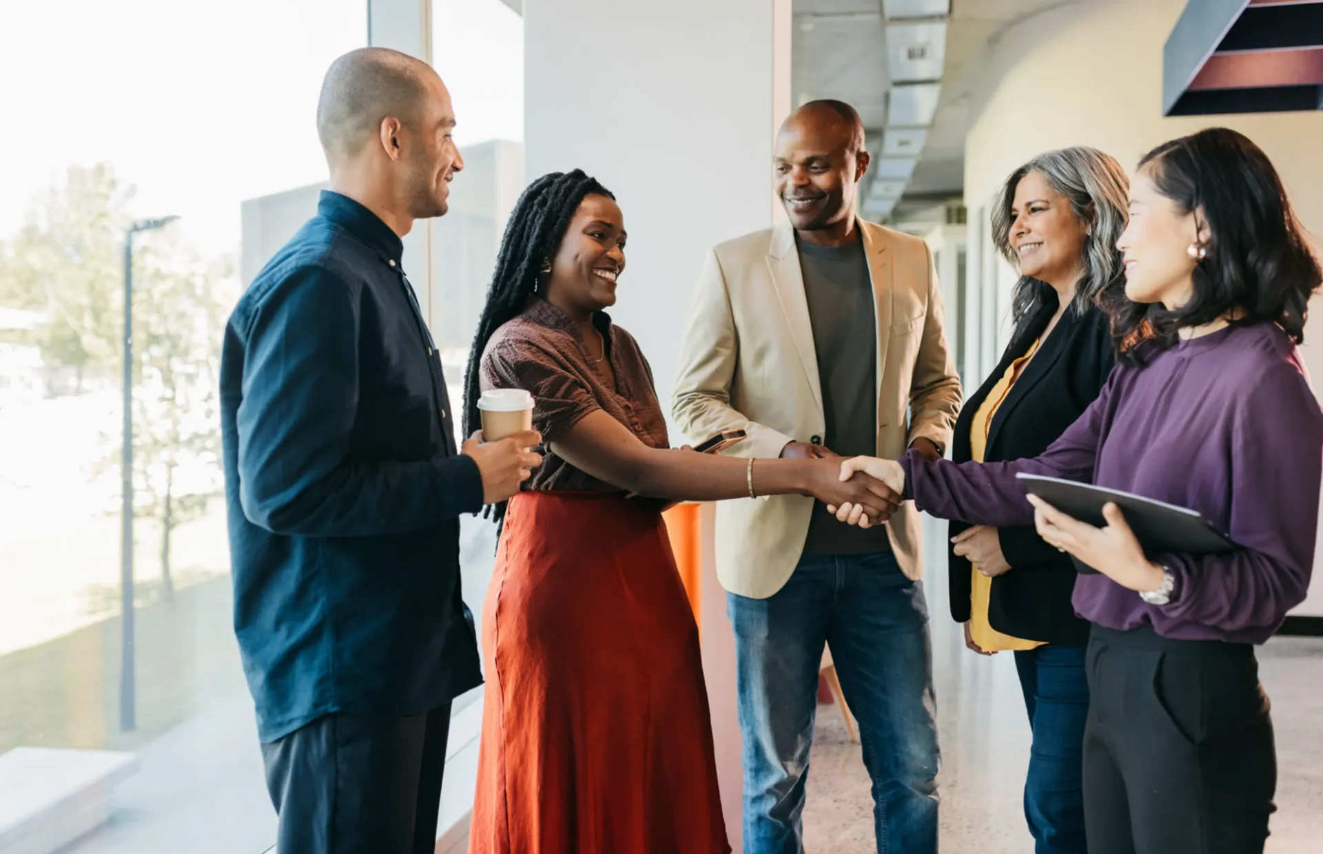 Group of people shaking hands and smiling.